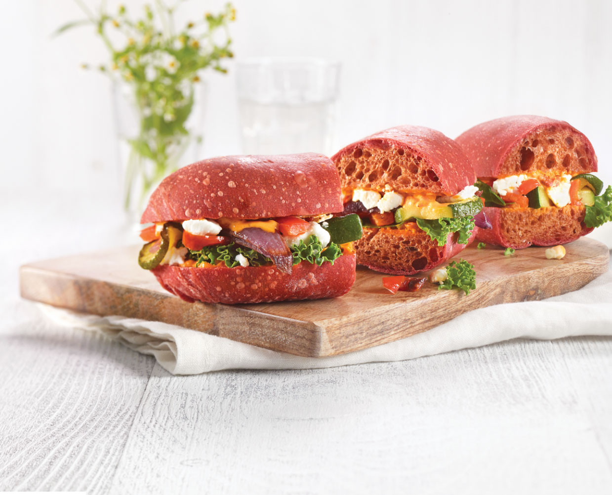 bistro-product Vegetable sandwiches presented on a wooden cutting board.
